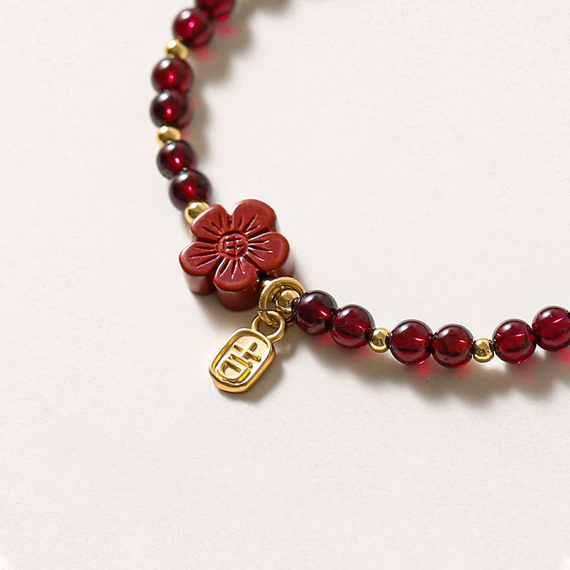 Rotes Granat Armband mit goldener Blume Anhänger Flachaufnahme