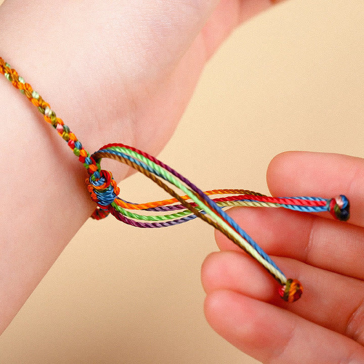Buntes Glücksarmband am Handgelenk getragen, mehrfarbige Fäden, traditionelles Armband.