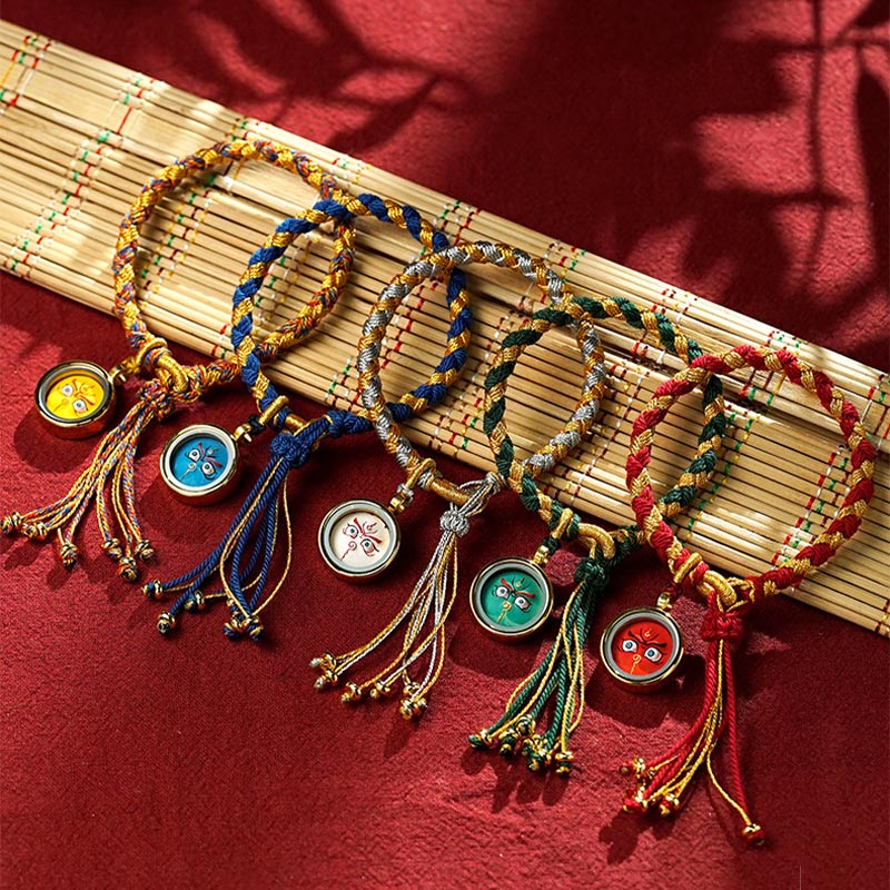 Fünf bunte Drachen-Armbänder mit Glücksmünzen auf Bambusmatte.