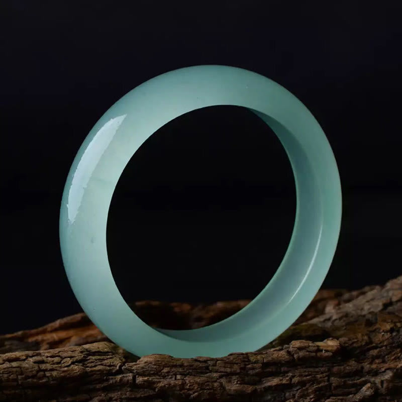 Hellgrünes Jade Armband auf Holz, poliert glänzend elegant