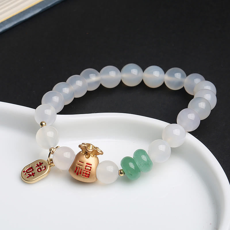 Jade Armband mit goldenen Charms und weißen Perlen elegant.