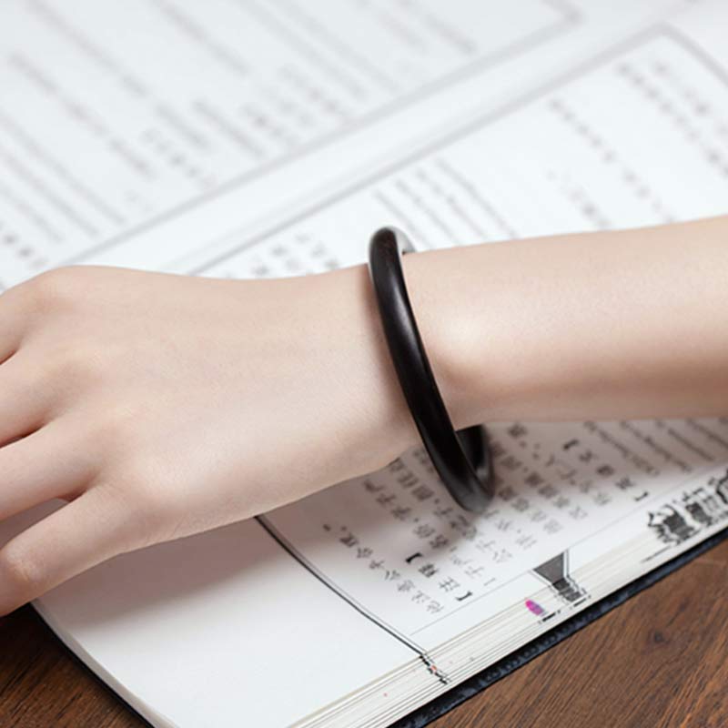 Schwarzes Ebenholz Armband am Handgelenk über Terminkalender getragen