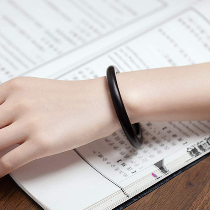 Schwarzes Ebenholz Armband am Handgelenk über Terminkalender getragen