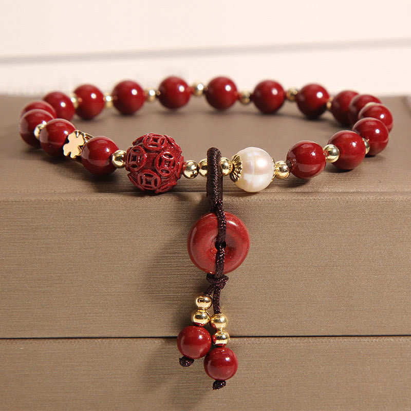 Rotes Armband mit Perlen und Anhänger auf Holzoberfläche elegant.