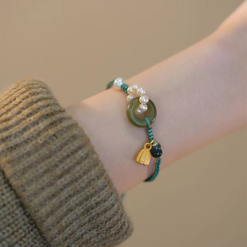 Armband Perle Jade mit goldener Quaste am Handgelenk getragen
