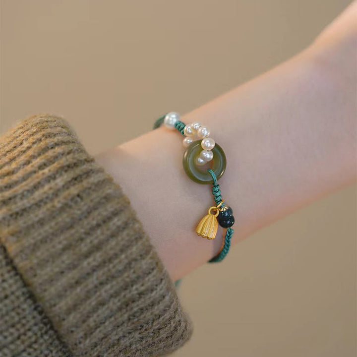 Armband Perle Jade mit goldener Quaste am Handgelenk getragen