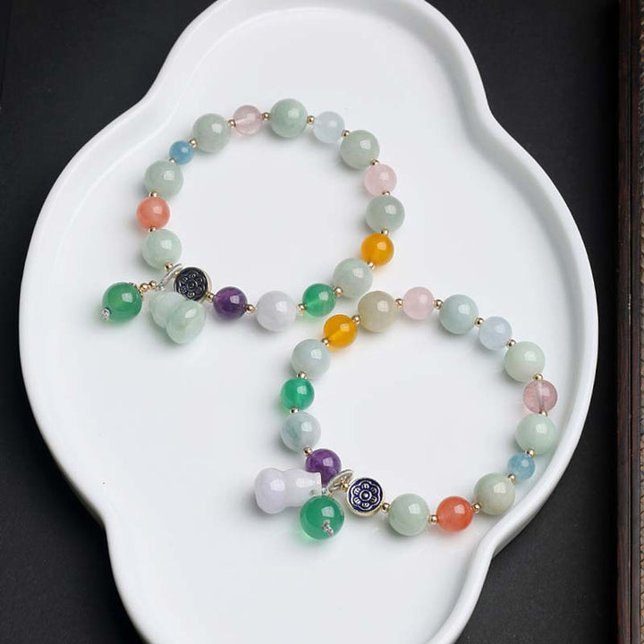 Jade Armband mit bunten Natursteinen auf weißer Schale elegant.