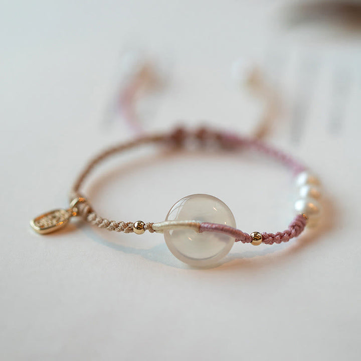 Armband – Frieden mit transparentem Mondstein und rosafarbenem Seidenfaden