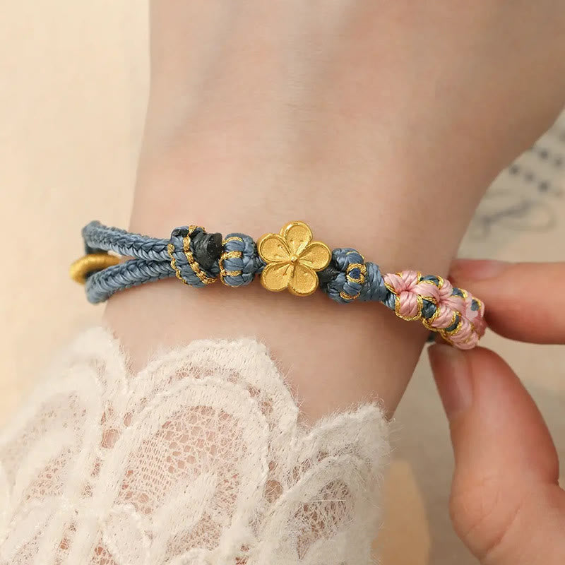 Armband Pfirsichblüte – Wohlstand mit goldener Blume am Handgelenk getragen
