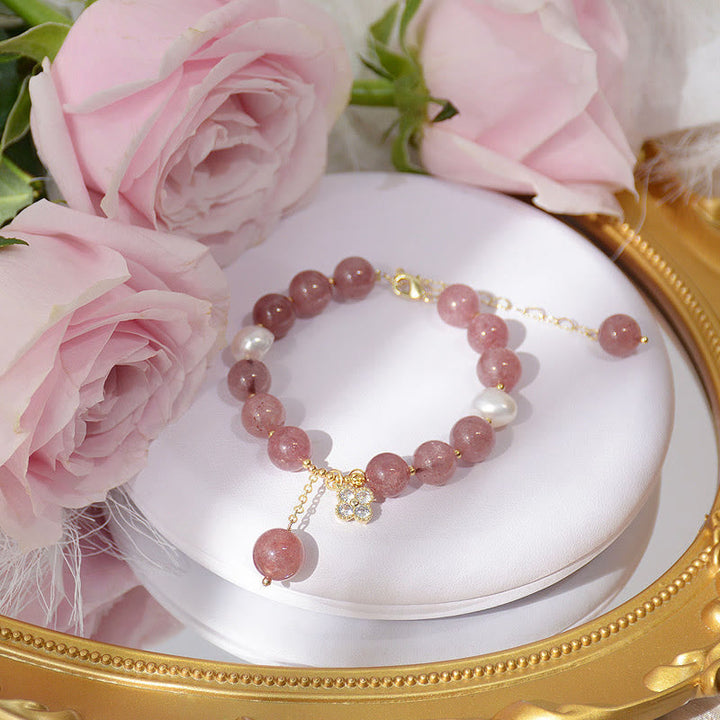 Armband Erdbeerquarz Perle Kleeblatt rosé elegant auf weißem Kissen