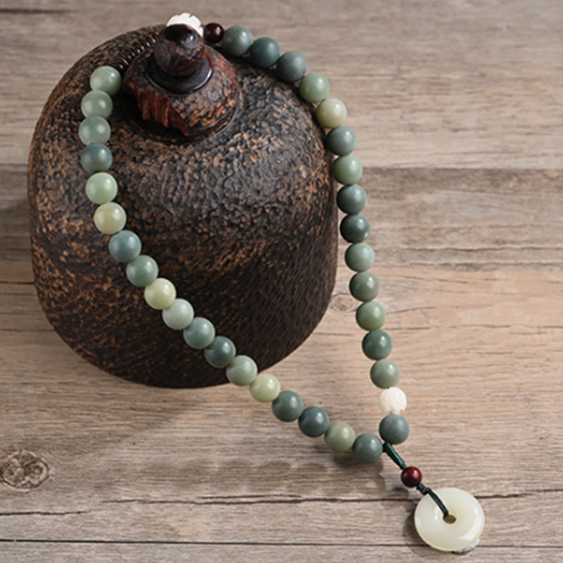 Bodhi Jade Lotus Armband mit grünen Steinen und weißem Anhänger elegant.
