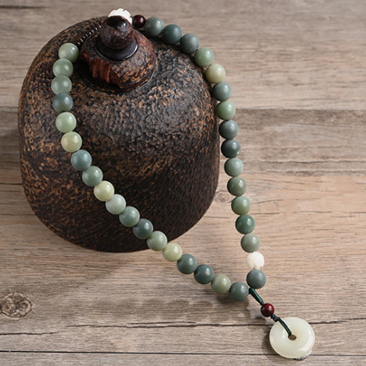 Bodhi Jade Lotus Armband mit grünen Steinen und weißem Anhänger elegant.