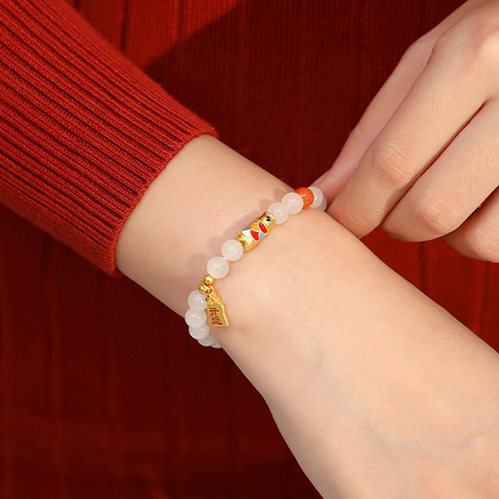 Weißes Jade Armband mit Koi Fisch Charm am Handgelenk getragen