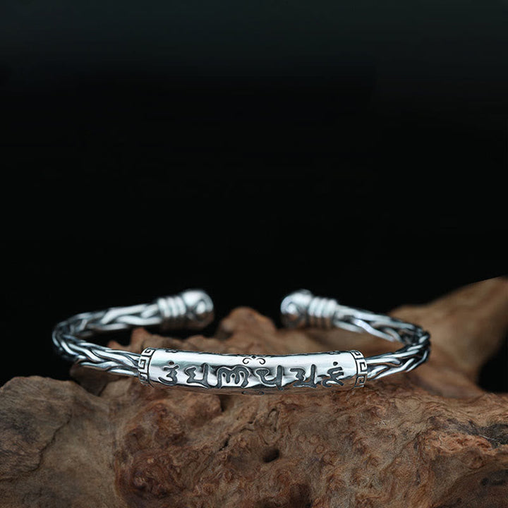 Silbernes Om Mani Padme Hum Armband auf Holz, detailliertes Design.