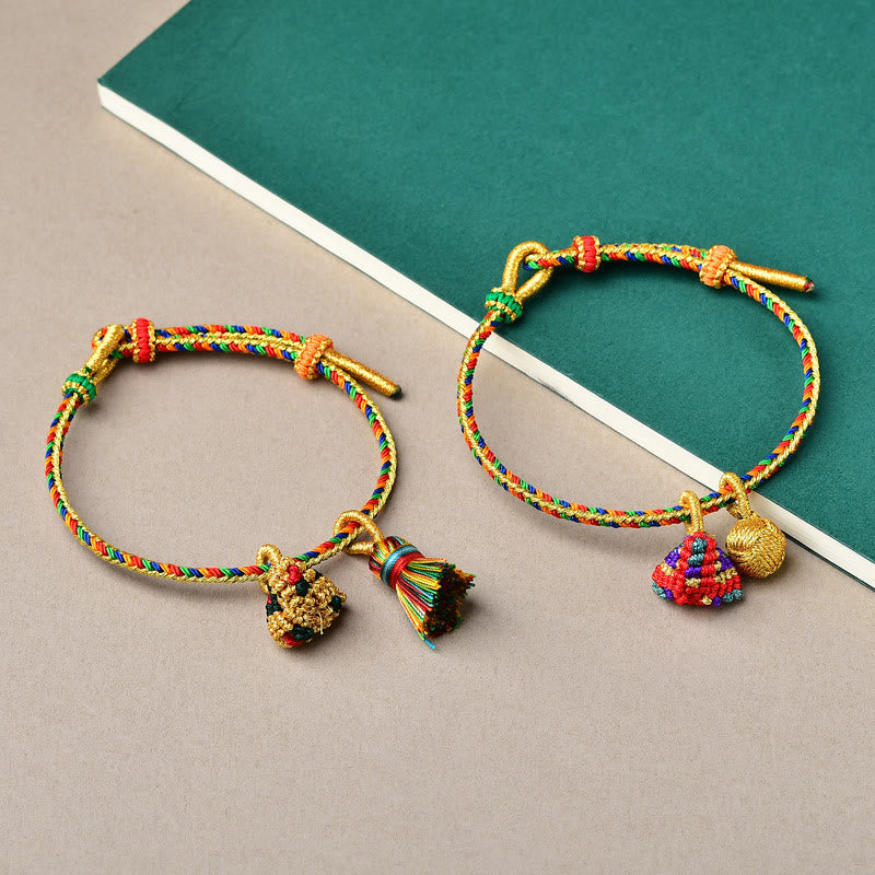 Bunte Armbänder mit goldenen Anhängern und Quasten Glücksbringer.