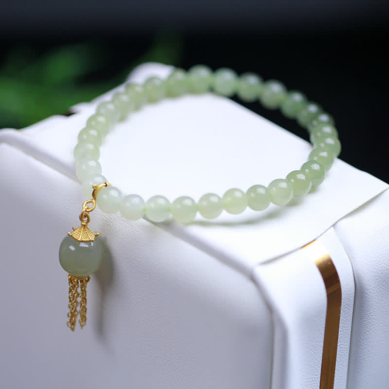 Hellgrünes Jade Armband mit goldener Quaste elegant präsentiert Handgelenk.