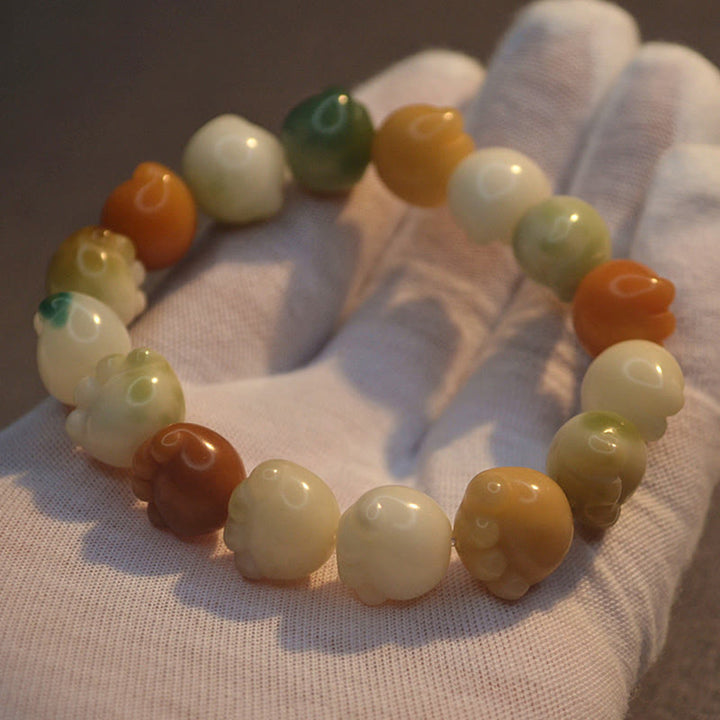 Bodhi-Armband mit Natursteinen in Creme, Orange und Grün getragen
