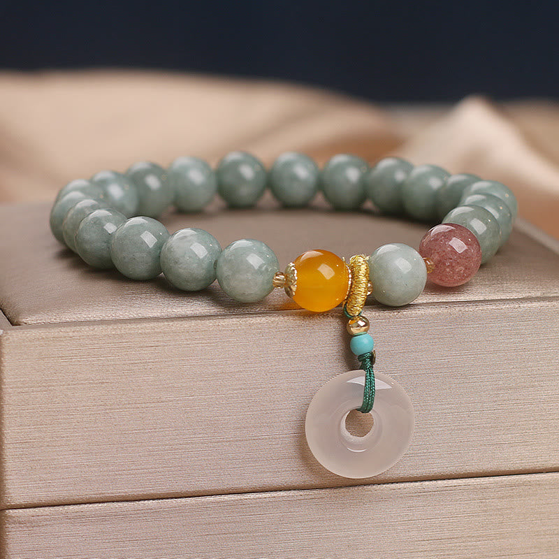 Armband Erdbeerquarz Jade mit goldenem Verschluss auf Holz