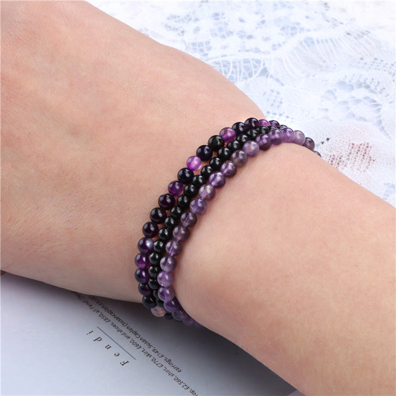 Armband Kristall – Frieden mit schwarzen und lila Perlen elastisch getragen