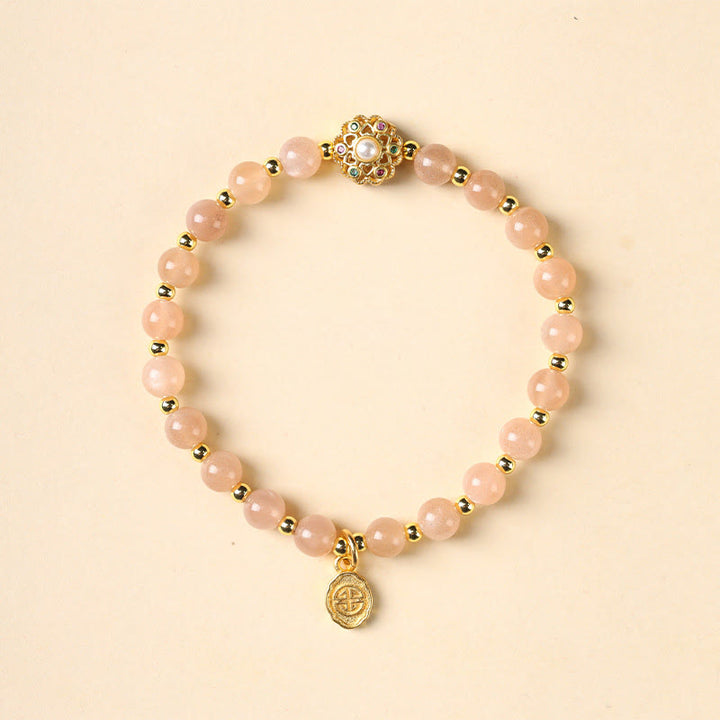 Erdbeerquarz Armband mit goldenen Perlen und Fu-Zeichen Anhänger elegant.