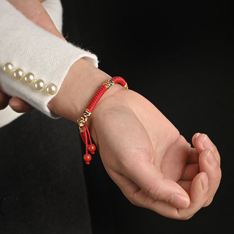 Rotes Armband Fünffarben – Schutz & Glück mit Perlendetails getragen