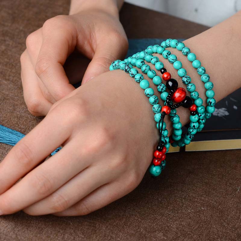 Türkis Armband mit schwarzem Onyx und roten Perlen elastisch getragen