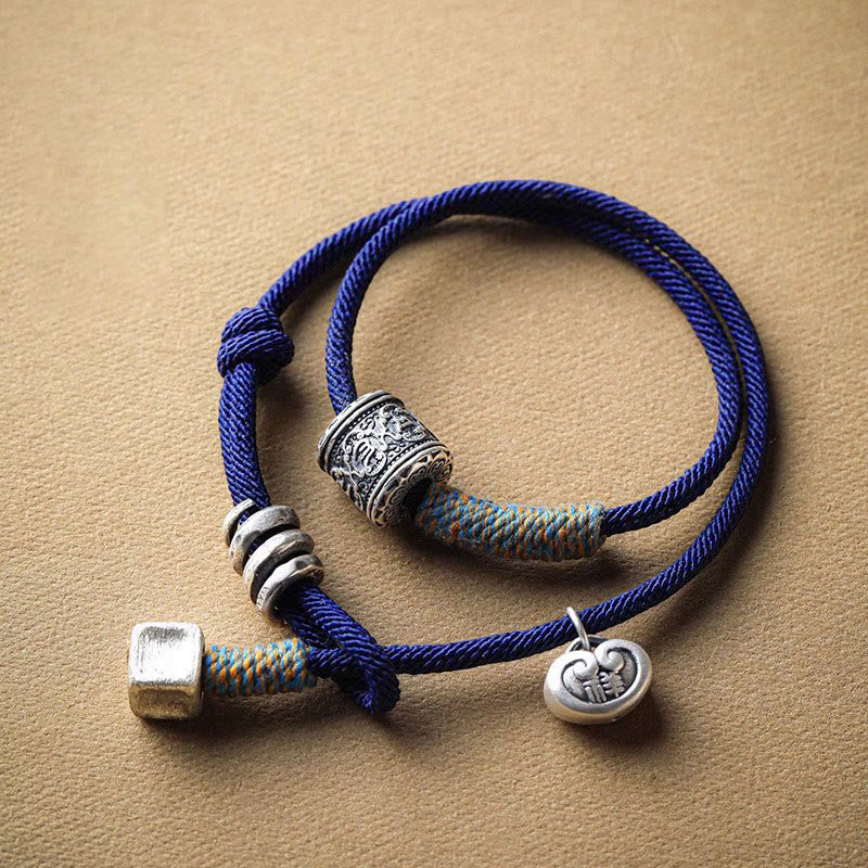 Blaues doppelgeflochtenes Armband Om Mani Padme Hum mit Metallverzierungen Flachaufnahme.