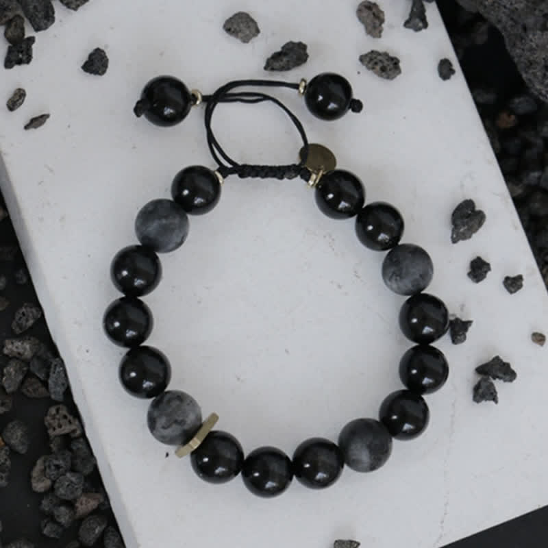 Schwarzer Obsidian Armband mit glänzenden Perlen elastisch gebunden.