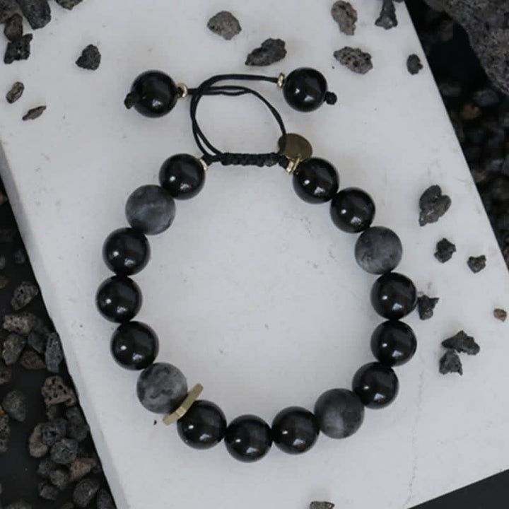 Schwarzer Obsidian Armband mit glänzenden Perlen elastisch gebunden.