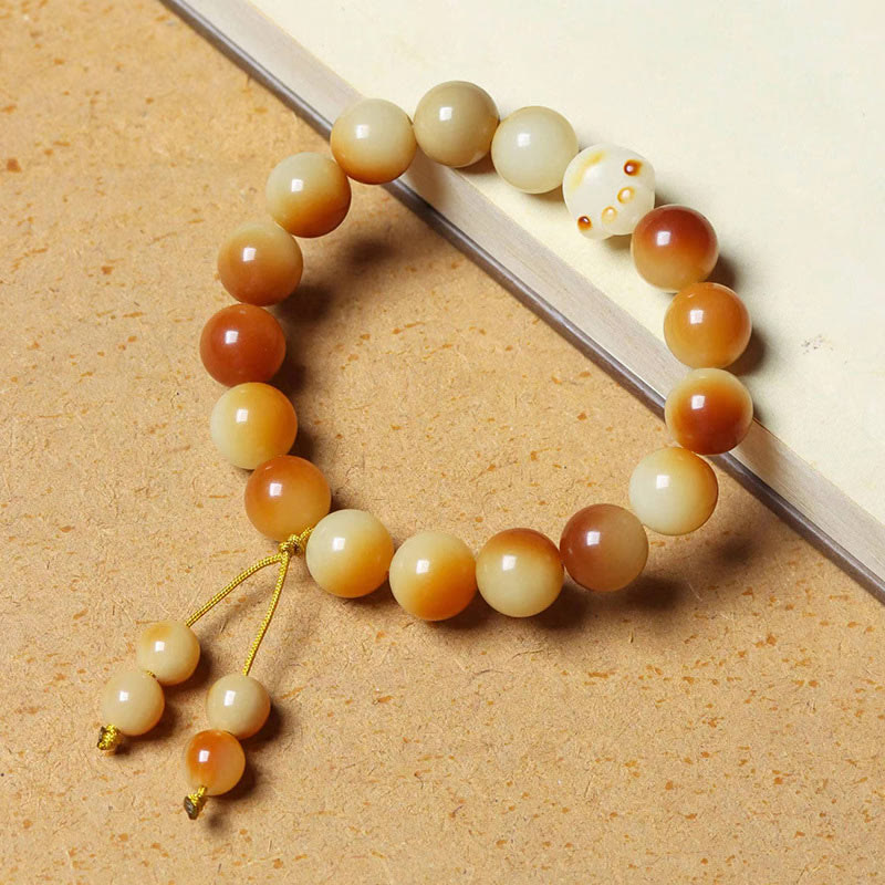 Bodhi-Armband mit cremefarbenen und bernsteinfarbenen Perlen, goldene Verzierungen, elastisch.