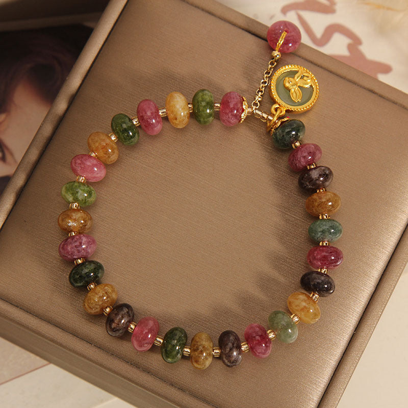 Armband Bunt Tourmaline Hase mit Golddetails und Charm am Handgelenk.