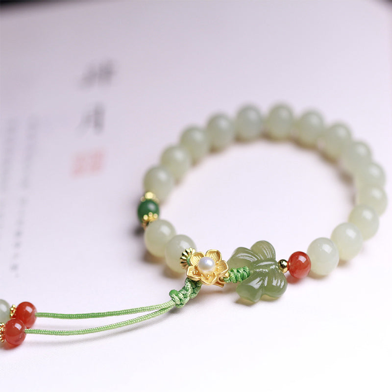 Jade Armband mit Schmetterling Charm, grüne Perlen elastisch getragen.