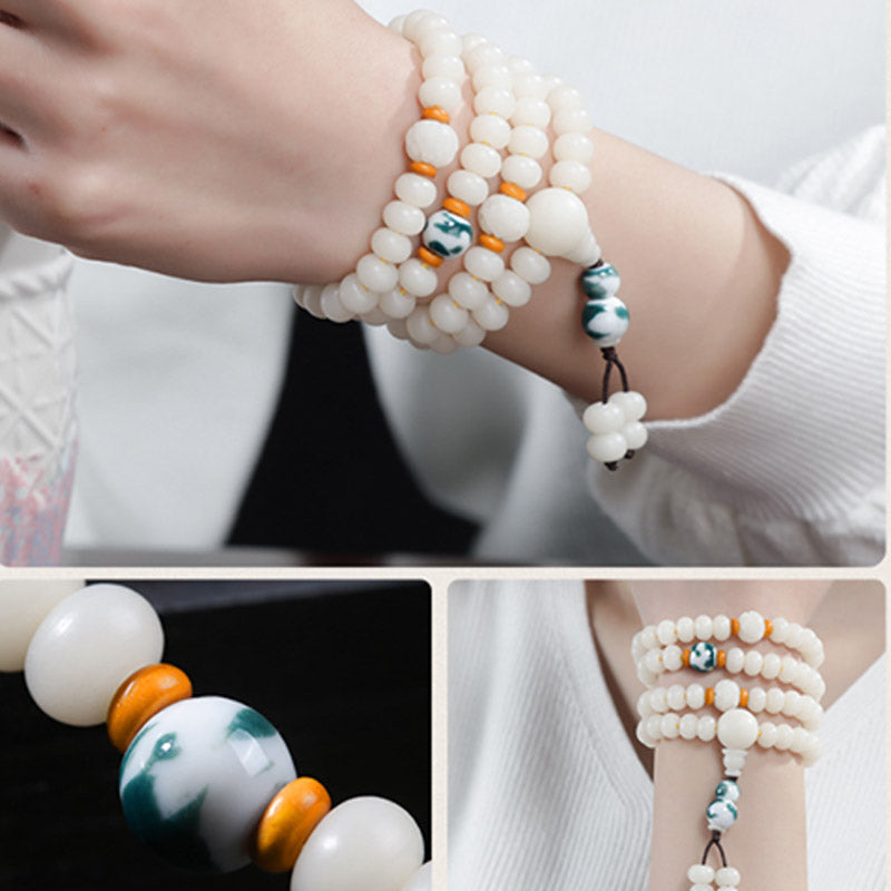 Bodhi Lotus Armband mit weißen Perlen und blauen Akzenten getragen