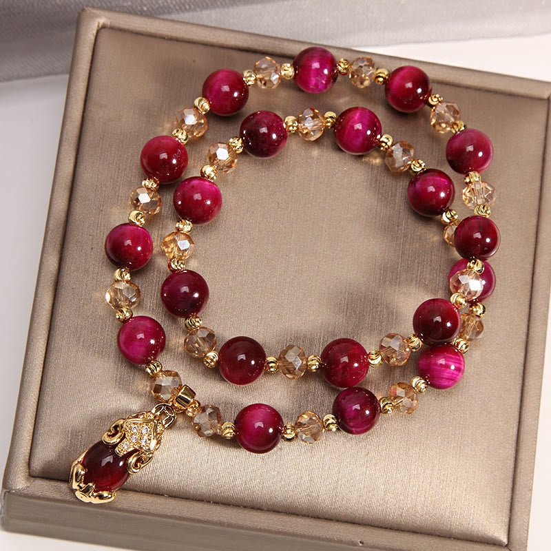 Rotes Perlen Armband mit Pixiu Anhänger goldfarbenen Elementen Flachlage