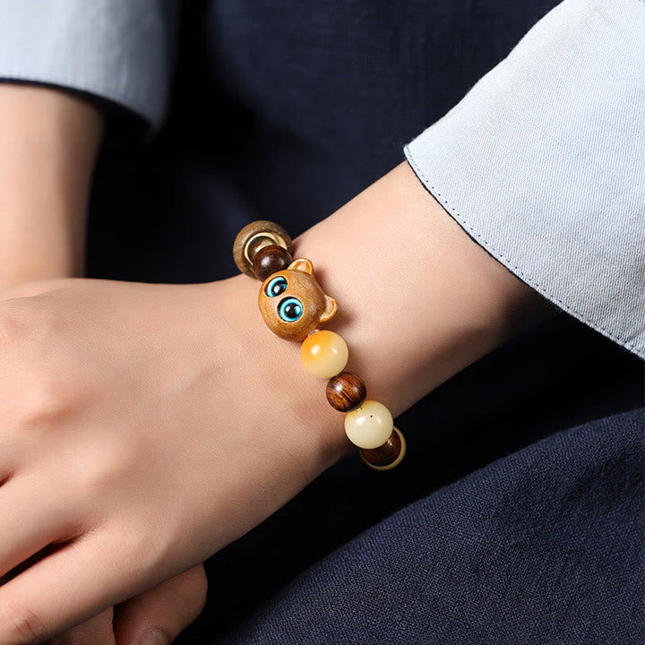 Armband Sandelholz Bodhi Katze am Handgelenk mit Bernstein Perlen.