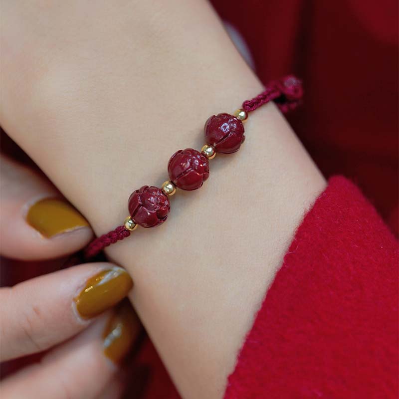 Armband Zinnober Jade Lotus – Ruhe am Handgelenk mit goldfarbenen Perlen getragen