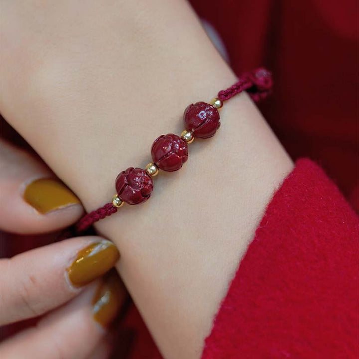 Armband Zinnober Jade Lotus – Ruhe am Handgelenk mit goldfarbenen Perlen getragen