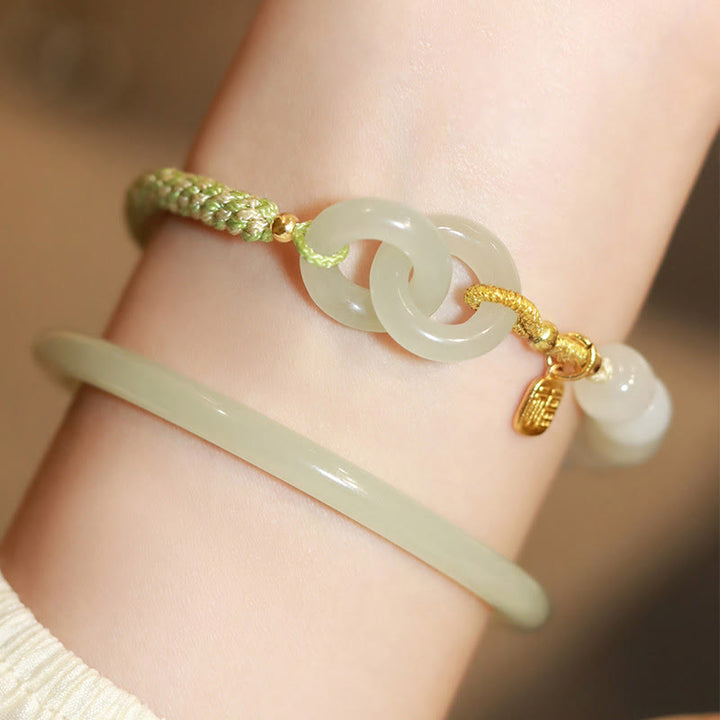 Armband Jade Fu-Zeichen grünes Seil elegant am Handgelenk getragen.