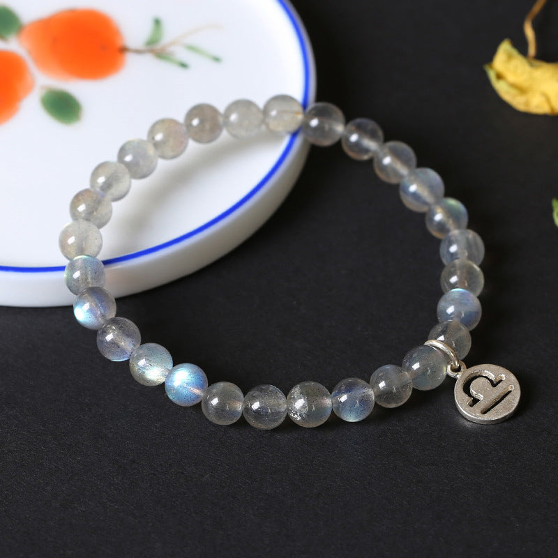 Armband Mondstein Mond mit silbernem Charm elegant getragen.