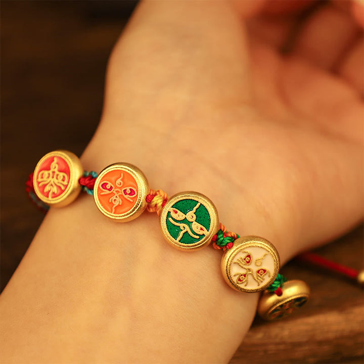 Goldenes Armband mit fünf Glücksmedaillons am Handgelenk getragen.