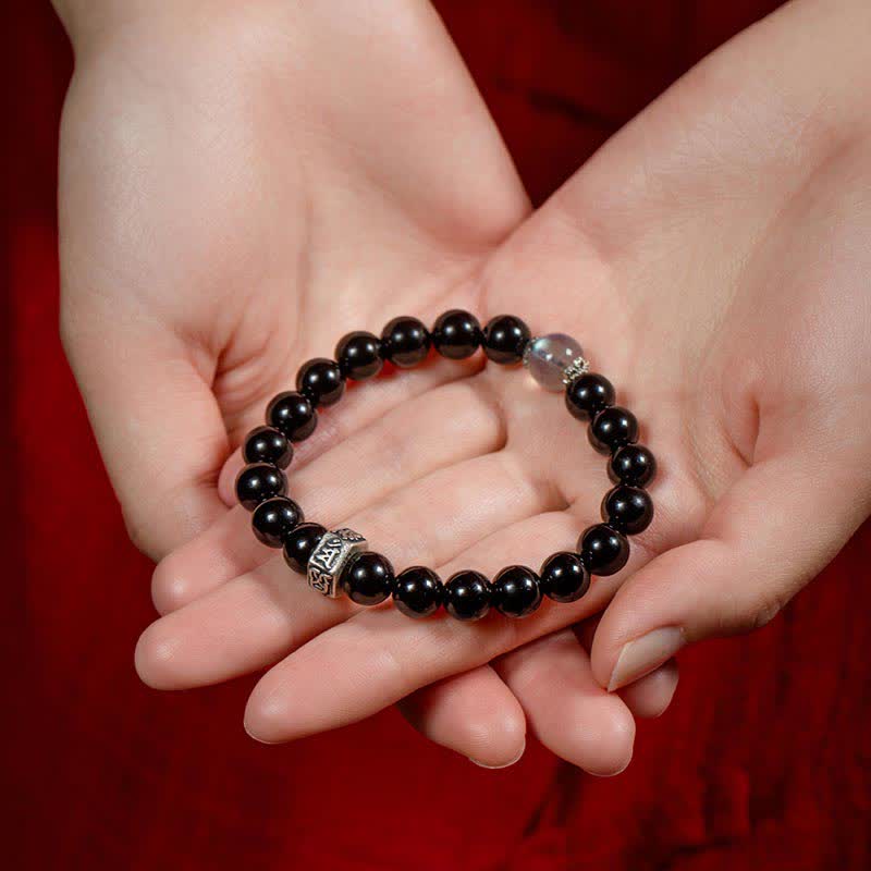 Schwarzes Obsidian Armband mit Silber Verschluss in Hand präsentiert elegant