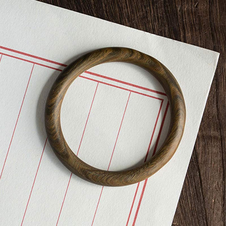 Sandelholz Ebenholz Armband Flatlays auf Notizbuch brauner Naturstein