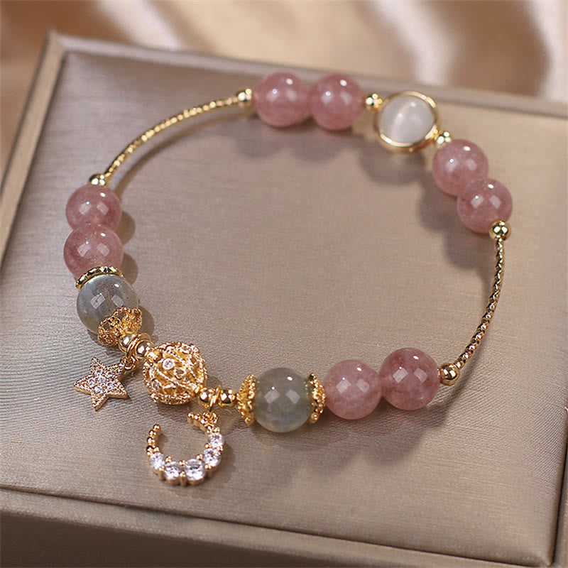 Elegantes Armband mit rosafarbenem Erdbeerquarz und Mondstein auf Präsentationstablett.