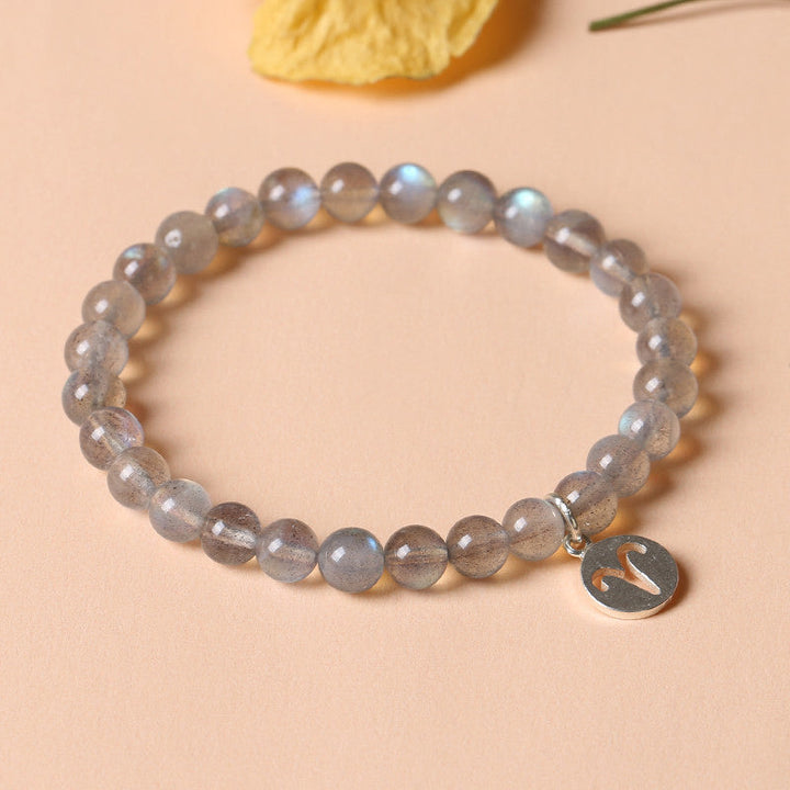 Armband Mondstein Mond mit Anhänger auf beigem Hintergrund eleganz