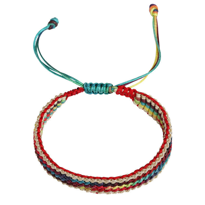 Tibetisches Armband Regenbogen bunt geflochten Schutzarmband flach fotografiert.