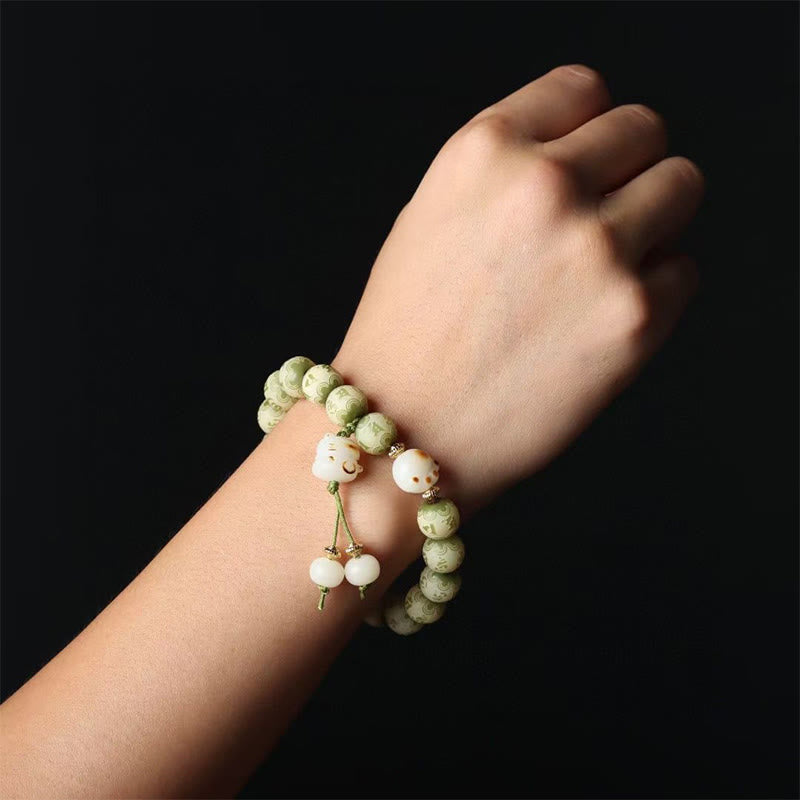 Bodhi Om Mani Padme Hum Armband am Handgelenk mit grünen Perlen getragen.