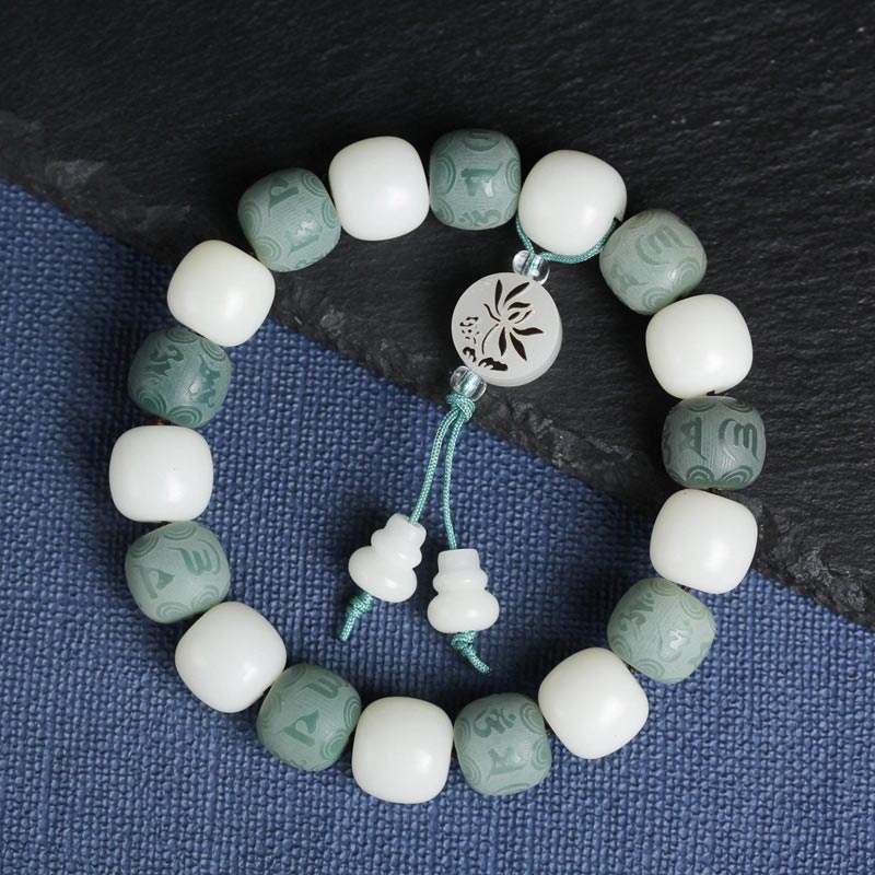 Armband Weiße Jade Bodhi Om Mani auf blauem Stoff Nahaufnahme