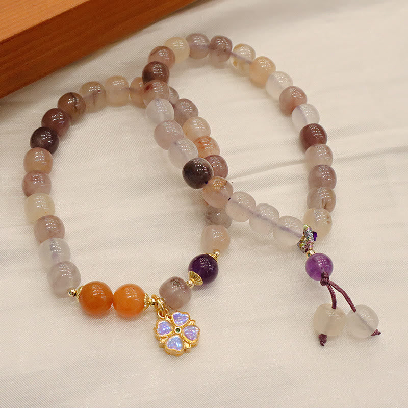 Jade Armband Wohlstand mit bernsteinfarbenen und lila Steinen elegant arrangiert.