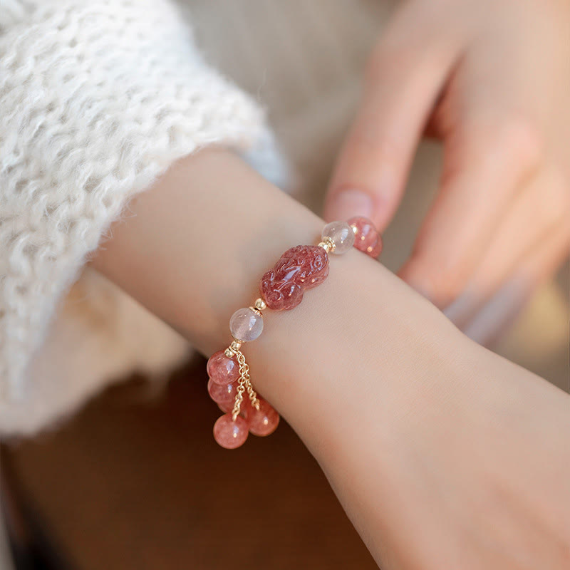 Armband Erdbeerquarz Mondstein Pixiu am Handgelenk mit rosa Steinen getragen