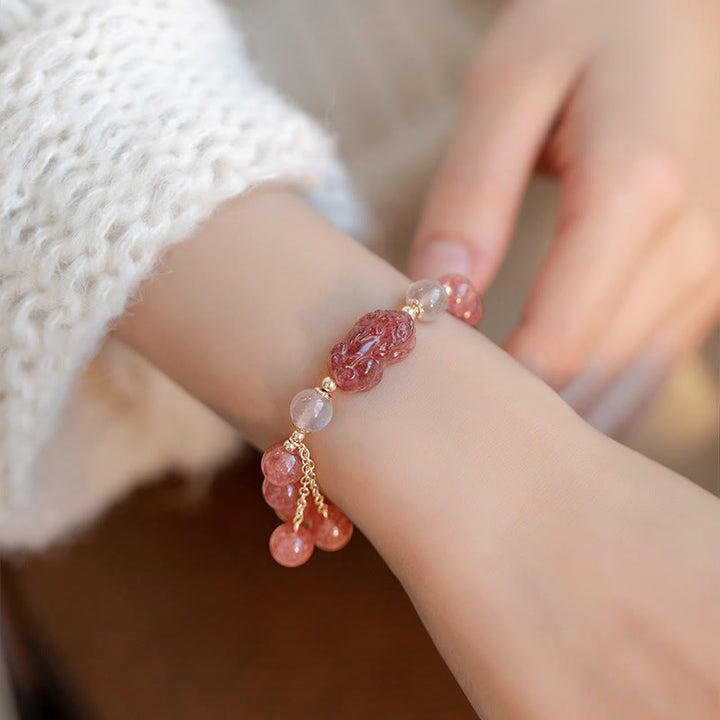 Armband Erdbeerquarz Mondstein Pixiu am Handgelenk mit rosa Steinen getragen